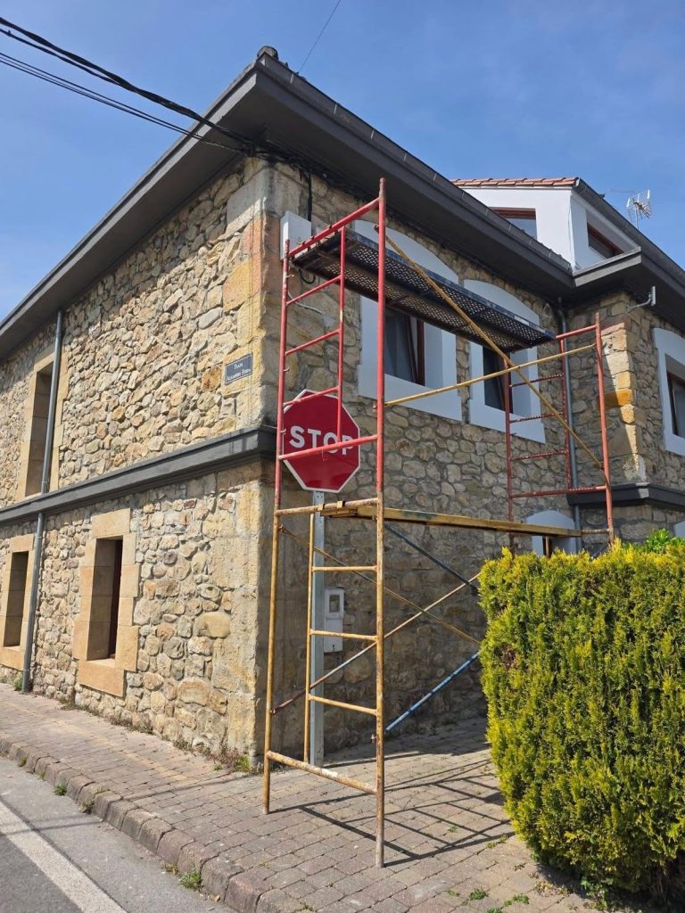 Fachada de mampostería en rehabilitación con andamio montado